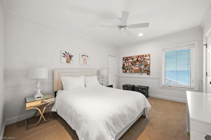 Bedroom with ornamental molding, carpet floors, and ceiling fan