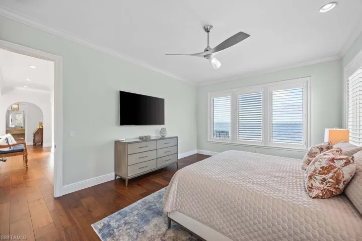 Bedroom featuring ceiling fan, ornamental molding, and dark hardwood / wood-style flooring