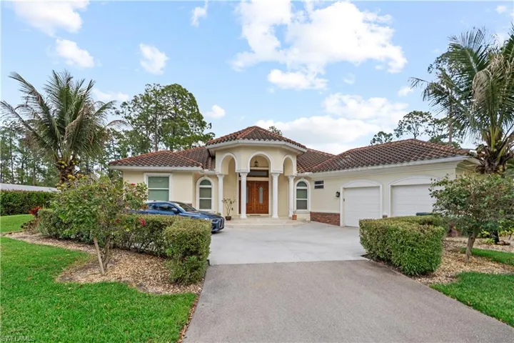 Mediterranean / spanish home featuring stucco siding, a garage, concrete driveway, a tile roof, and a front yard