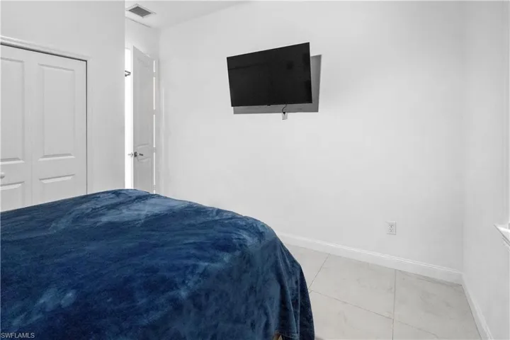 Bedroom with light tile patterned floors and a closet