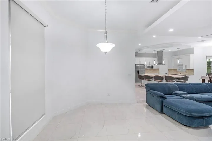 Living room with recessed lighting, crown molding, and light marble finish floors