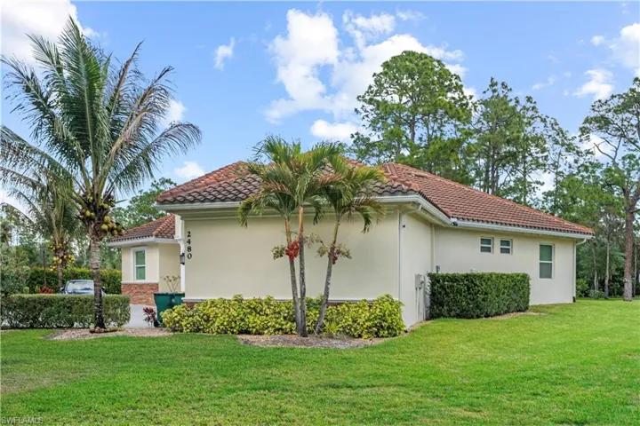 View of home's exterior featuring stucco siding, a lawn, and a tiled roof