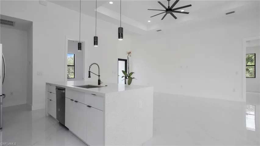 Kitchen with stainless steel dishwasher, modern cabinets, recessed lighting, white cabinetry, and decorative light fixtures