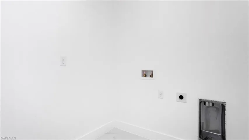 Washroom with electric dryer hookup, hookup for a washing machine, and marble look tile flooring