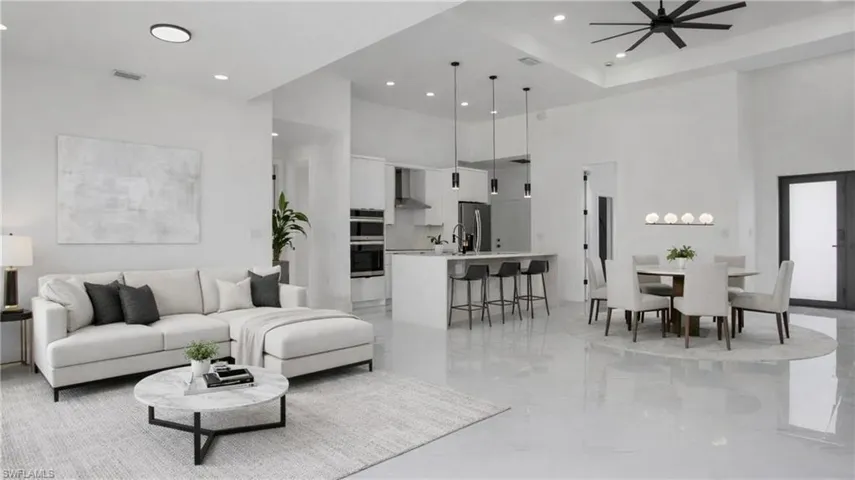 Virtually Staged Living area with a high ceiling, recessed lighting, a ceiling fan, and light marble finish flooring