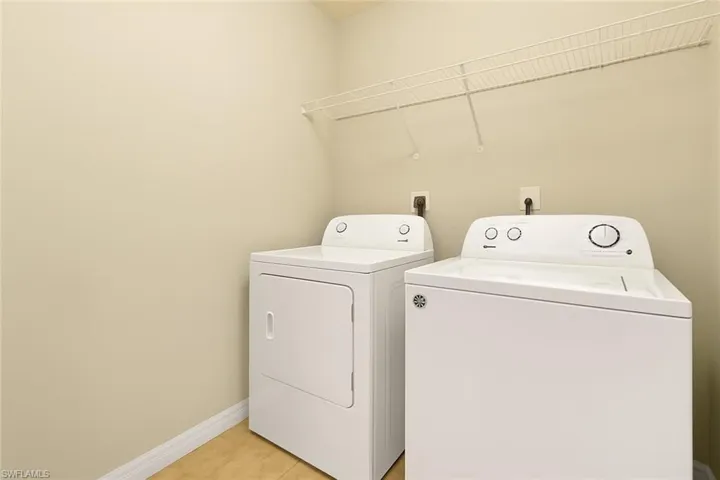 Laundry area featuring separate washer and dryer and light tile patterned flooring