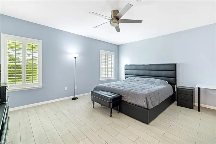 Bedroom with multiple windows, wood finish floors, and a ceiling fan