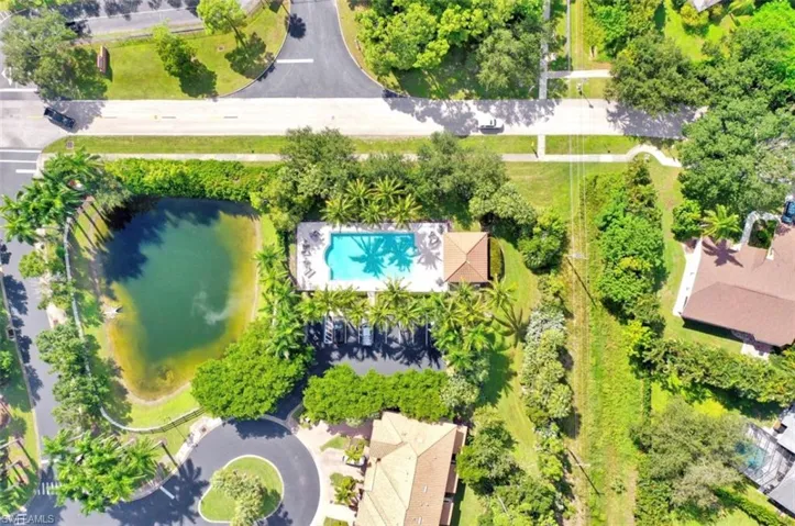 Bird's eye view of a nearby body of water and a pool area