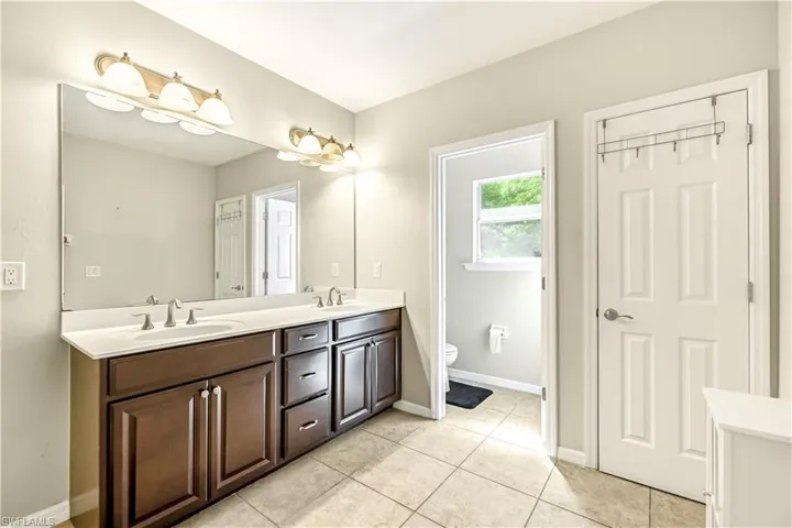 Full bathroom featuring double vanity and light tile patterned floors