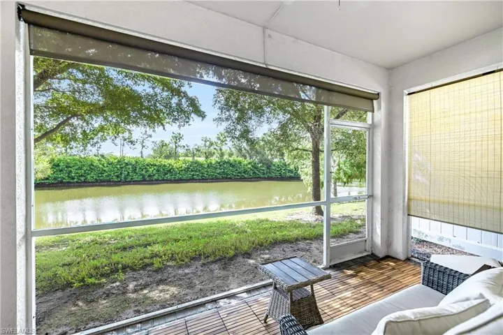 Sunroom featuring a water view and view of scattered trees