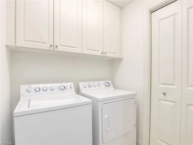 Washroom with washer and dryer and cabinets