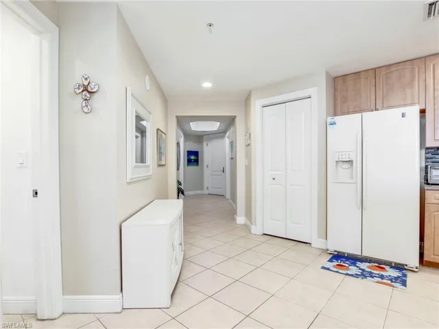 Kitchen featuring light tile floors and white fridge with ice dispenser
