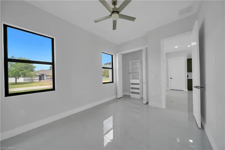 Unfurnished bedroom featuring multiple windows, baseboards, and ceiling fan