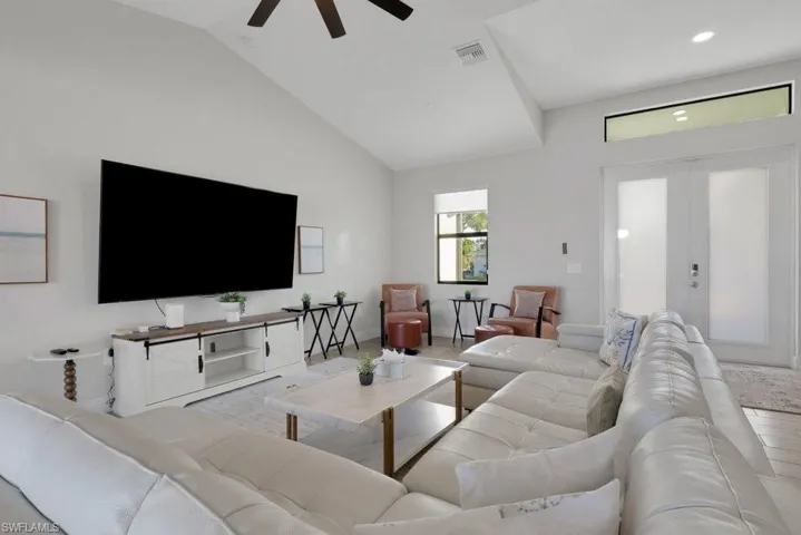 Vaulted ceilings, white walls, and a ceiling fan with light