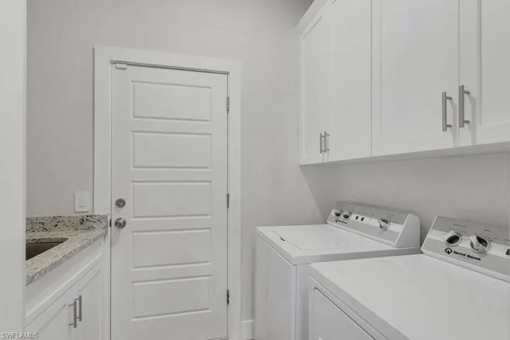 White shaker-style cabinetry, granite countertop, undermount sink, and recessed lighting