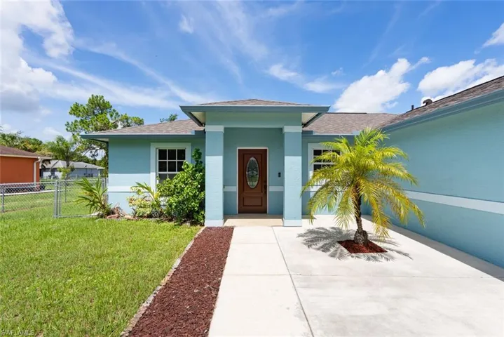 Ranch-style house featuring a garage and a front yard