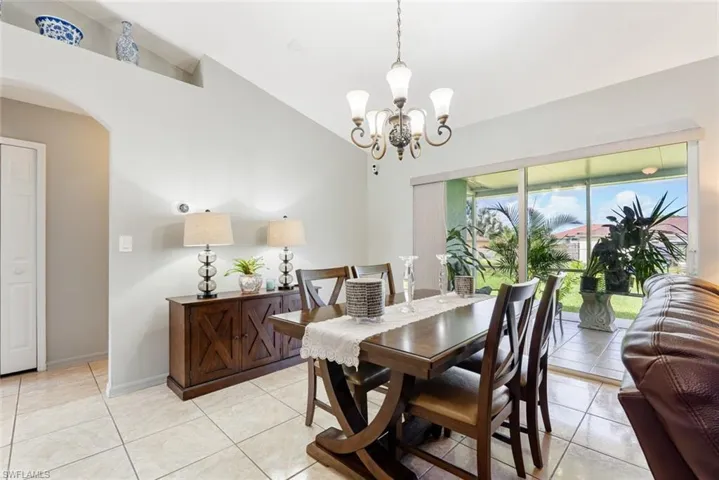 Tiled dining area with an inviting chandelier and lofted ceiling