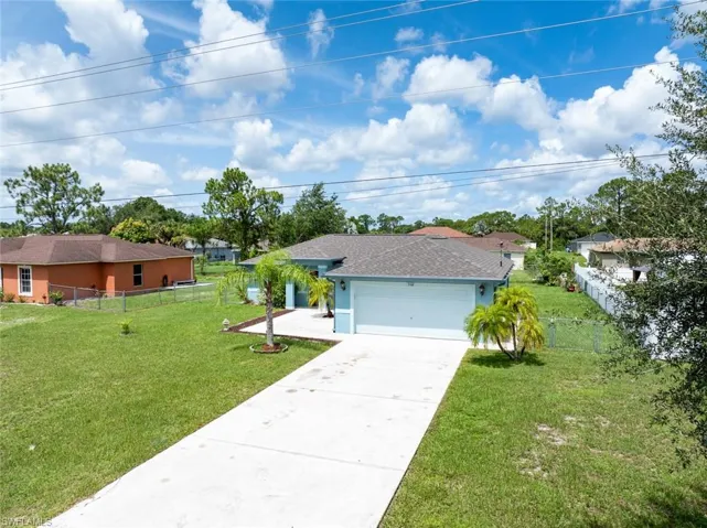 Ranch-style home with a garage and a front lawn