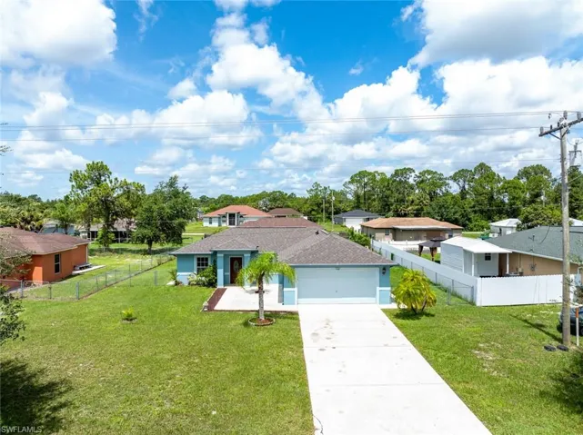 Ranch-style home with a garage and a front lawn