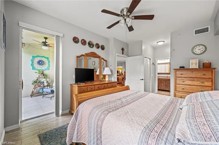 Bedroom with ceiling fan, light hardwood / wood-style floors, connected bathroom, and a closet