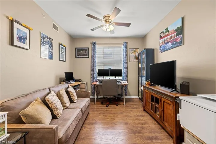 Office space with hardwood / wood-style floors and ceiling fan