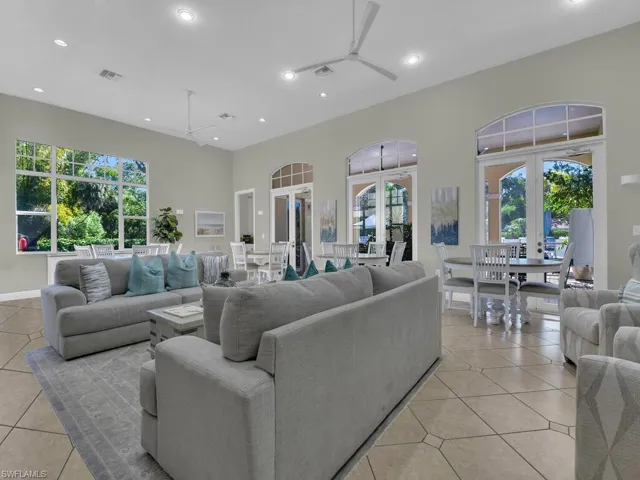 Living room featuring plenty of natural light, a high ceiling, light tile patterned floors, recessed lighting, and french doors