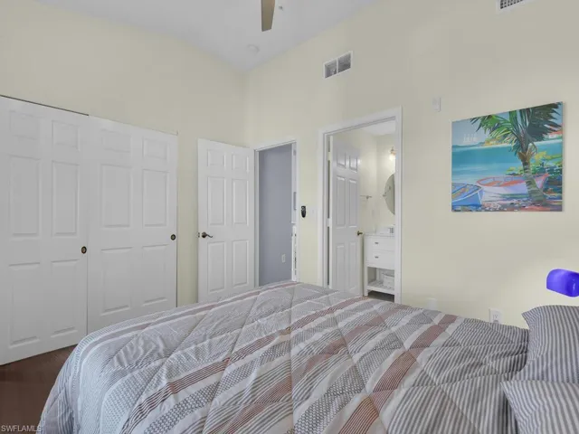 Bedroom with a closet, a ceiling fan, wood finished floors, and connected bathroom