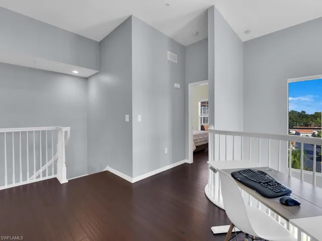 Office area featuring dark wood finished floors and a high ceiling