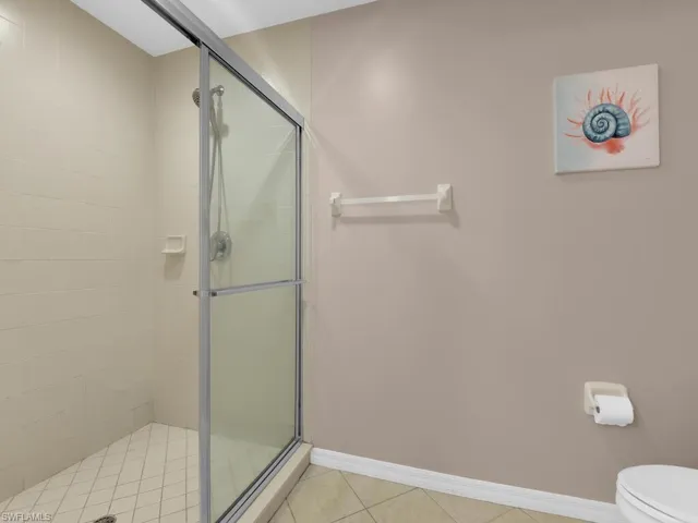 Bathroom featuring a shower stall and light tile patterned floors