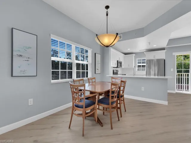 Dining room with light wood-style flooring and recessed lighting