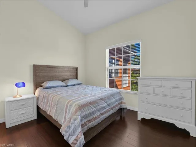 Bedroom featuring dark wood finished floors, lofted ceiling, and ceiling fan