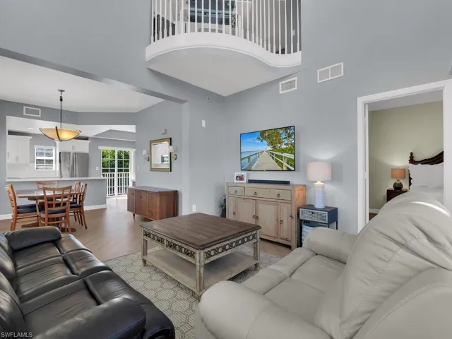 Living room with wood finished floors and a high ceiling