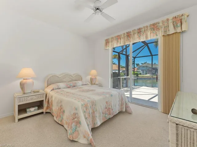 Bedroom featuring access to exterior, carpet flooring, a ceiling fan, and a water view