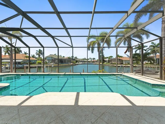 Outdoor pool featuring a lanai, a patio, and a water view