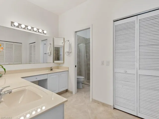 Full bath featuring a sink, a closet, tile patterned floors, and double vanity