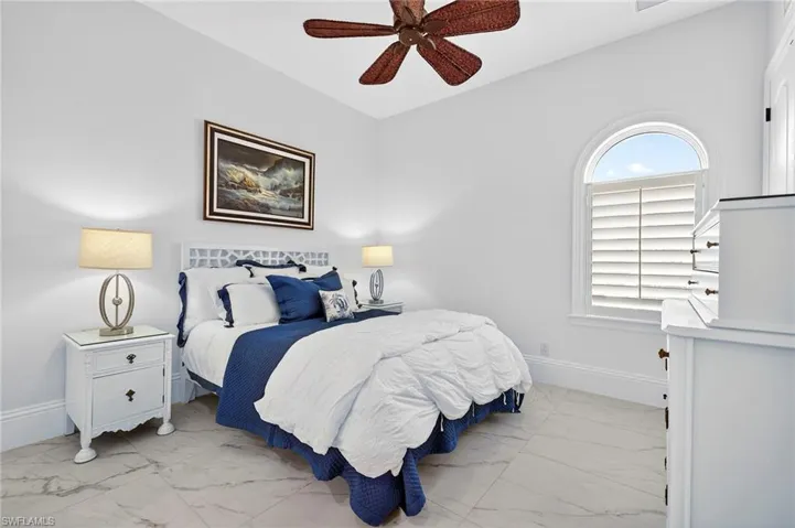 Bedroom with light marble finish flooring and ceiling fan