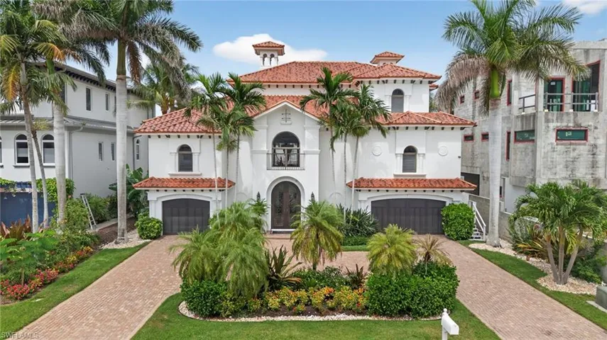 Mediterranean / spanish-style house featuring an attached garage, stucco siding, decorative driveway, and a tile roof