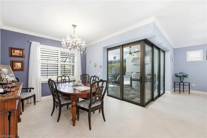 Dining room with a chandelier, ornamental molding, and light tile patterned flooring