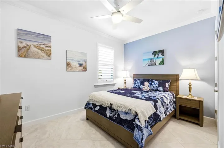Tiled bedroom with crown molding and ceiling fan
