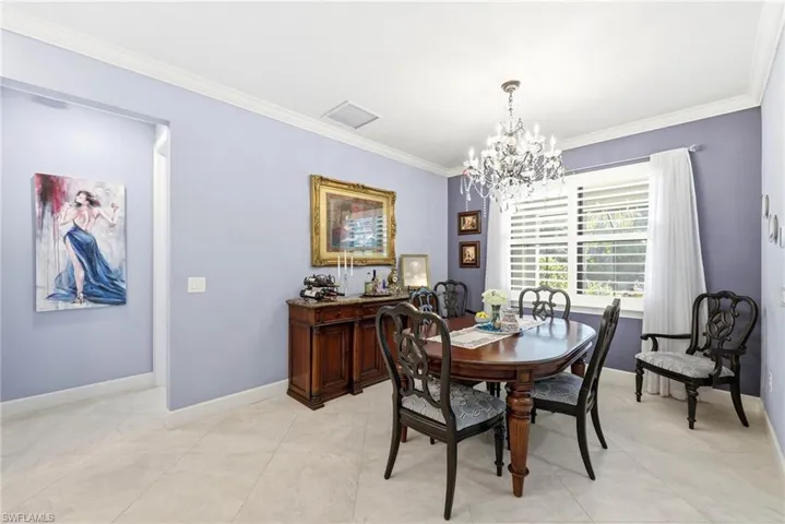 Dining space with ornamental molding and a chandelier