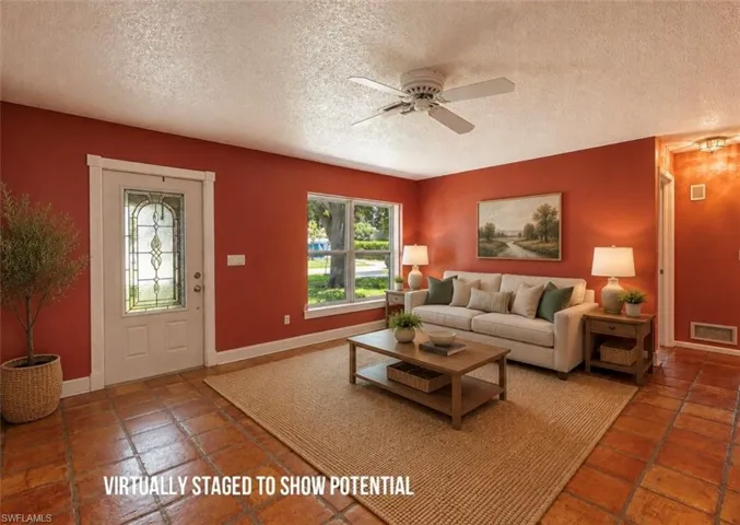 VIRTUALLY STAGED Entryway featuring a decorative glass door, square tile flooring, and a ceiling fan