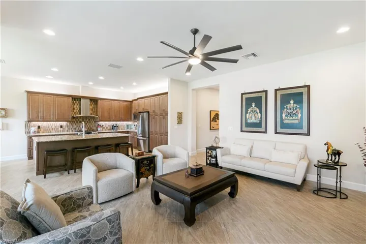 Living area with ceiling fan, recessed lighting, and baseboards