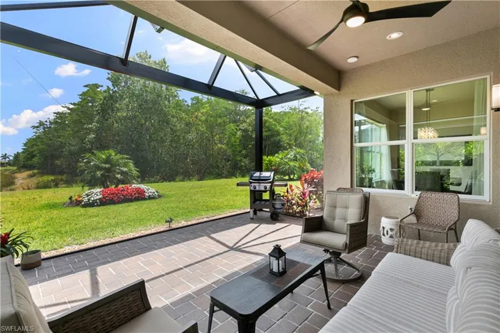 View of patio with ceiling fan, a grill, and a lanai