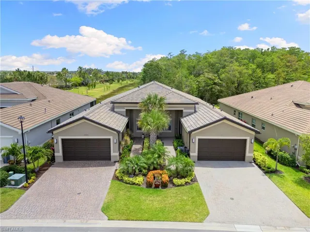 Ranch-style home featuring stucco siding, driveway, and a front yard