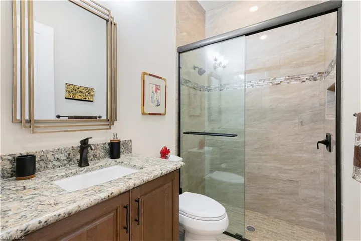 Full bath with vanity, toilet, and a stall shower