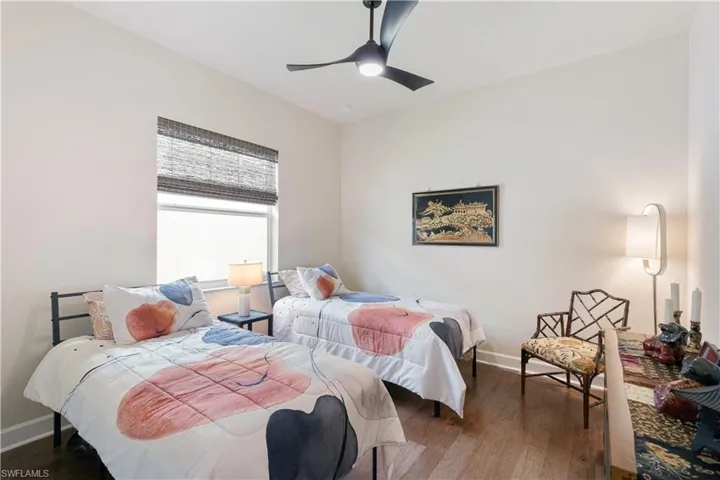 Bedroom featuring baseboards, wood finished floors, and ceiling fan