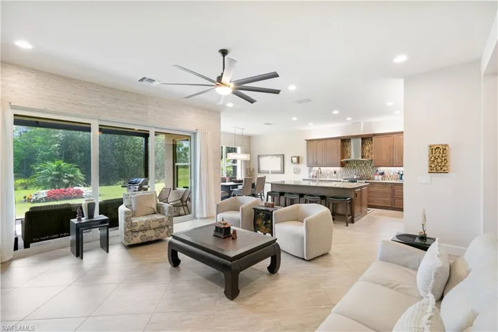 Living area featuring a ceiling fan, plenty of natural light, light tile patterned floors, and recessed lighting