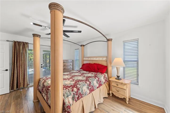 Bedroom with access to outside, wood finished floors, and a ceiling fan