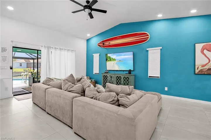 Living room featuring vaulted ceiling, a ceiling fan, and recessed lighting
