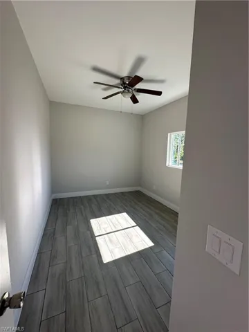 Spare room featuring dark hardwood / wood-style floors and ceiling fan